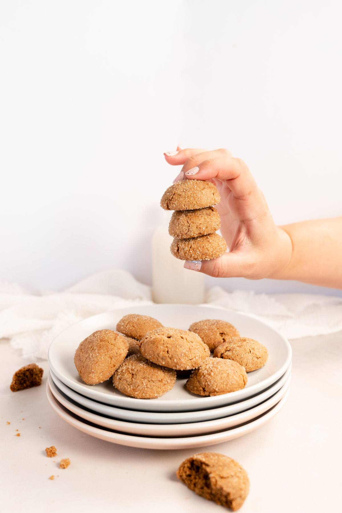 a female hand holding stacked vegan biscuits