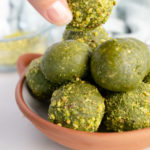 matcha balls in a brown bowl with one held by a female hand