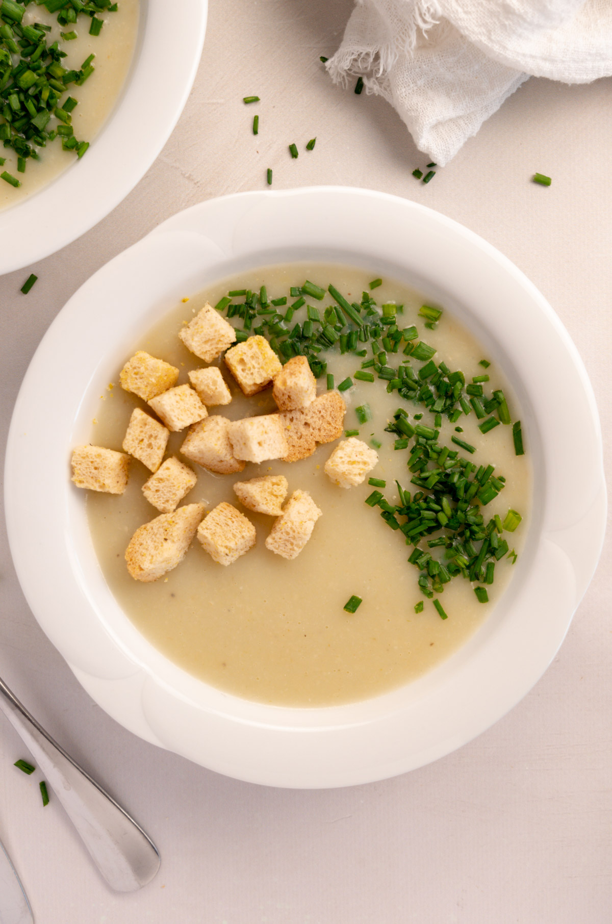 a bowl of potato and leek soup with croutons on top