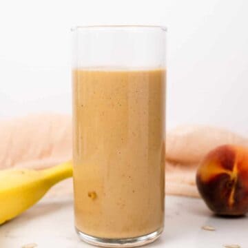 banana peach smoothie in a glass cup