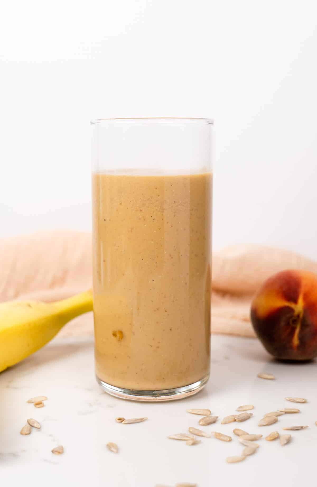 banana peach smoothie in a glass cup