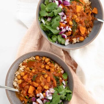 two grey bowls of chickpea spinach curry