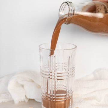 a bottle of cocoa oat milk being poured into a glass
