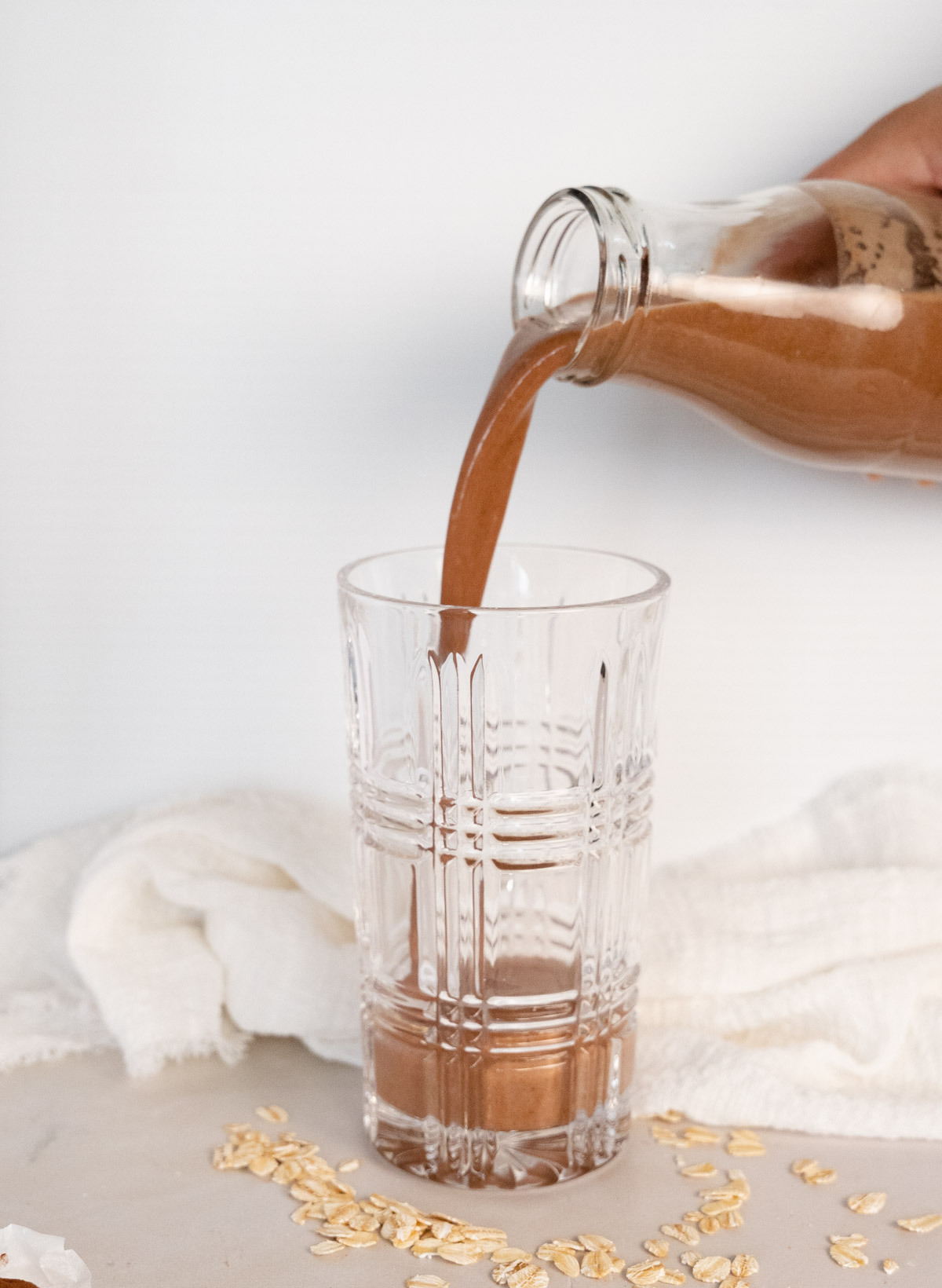 a bottle of cocoa oat milk being poured into a glass