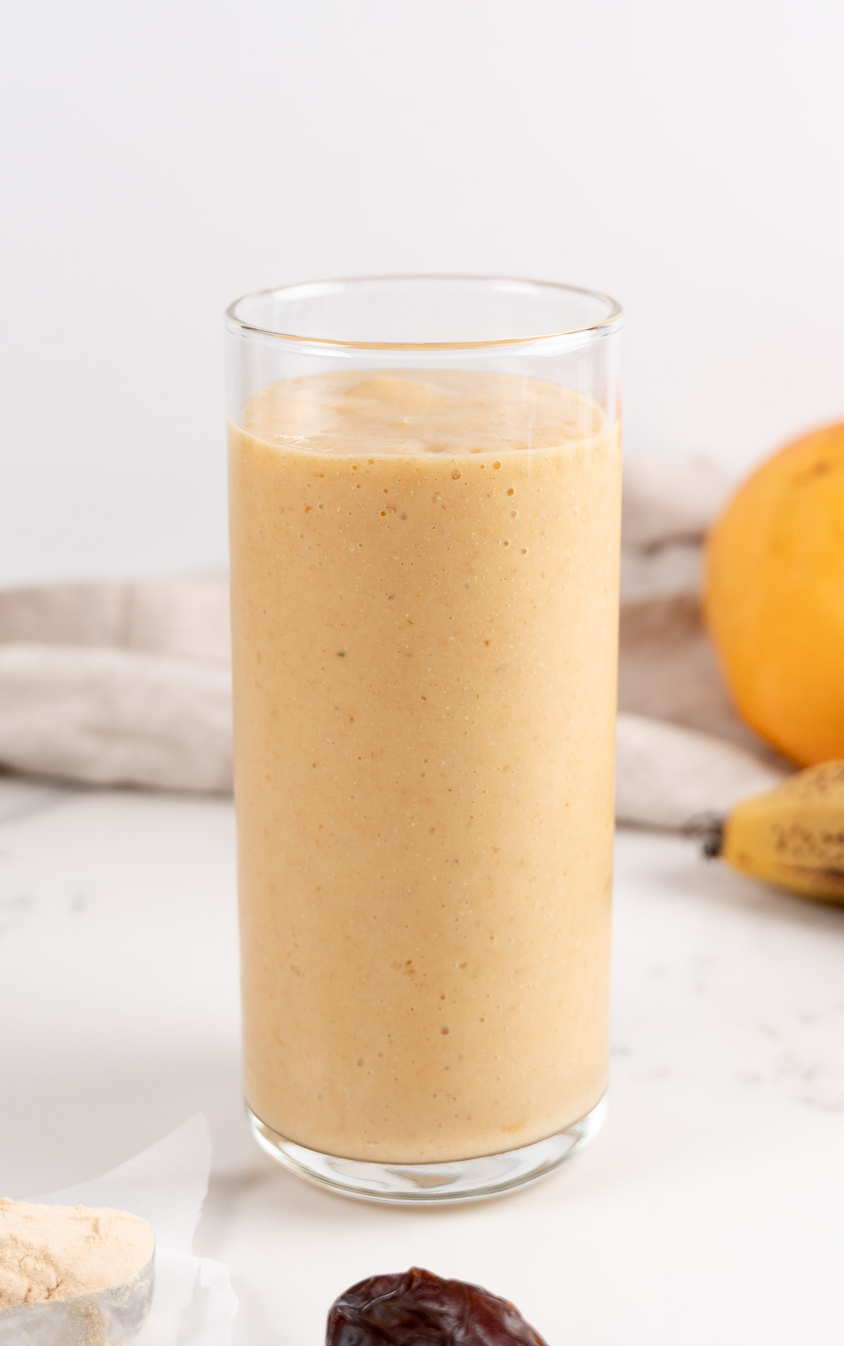 mango pineapple banana smoothie in a glass