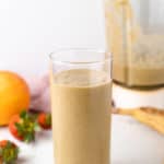 mango strawberry banana peanut butter smoothie in a glass cup