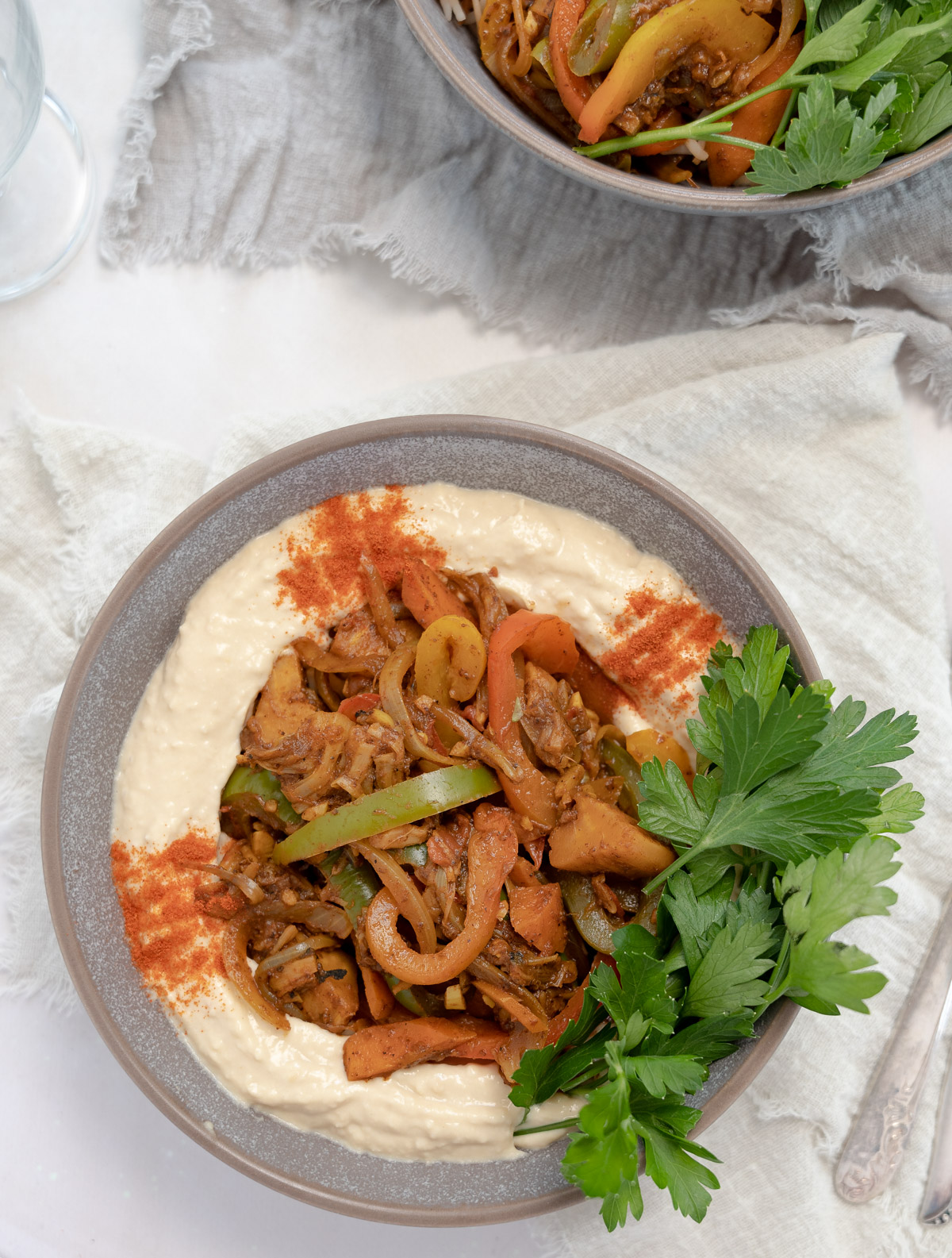a grey bowl with hummus topped with ghallaba