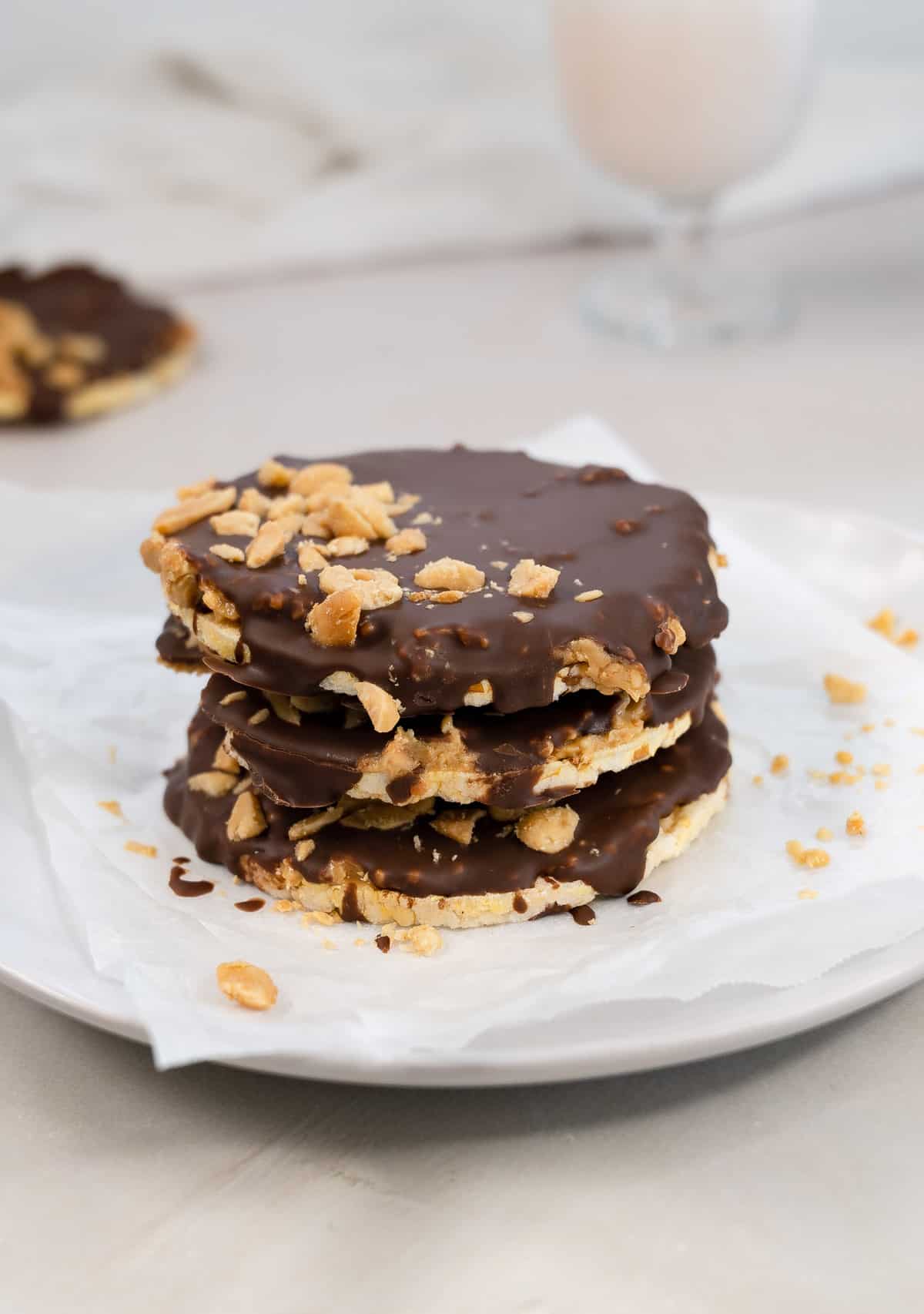 a stack of 3 chocolate and peanut butter covered rice cakes on a white plate