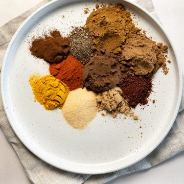 different coloured spices in a white plate