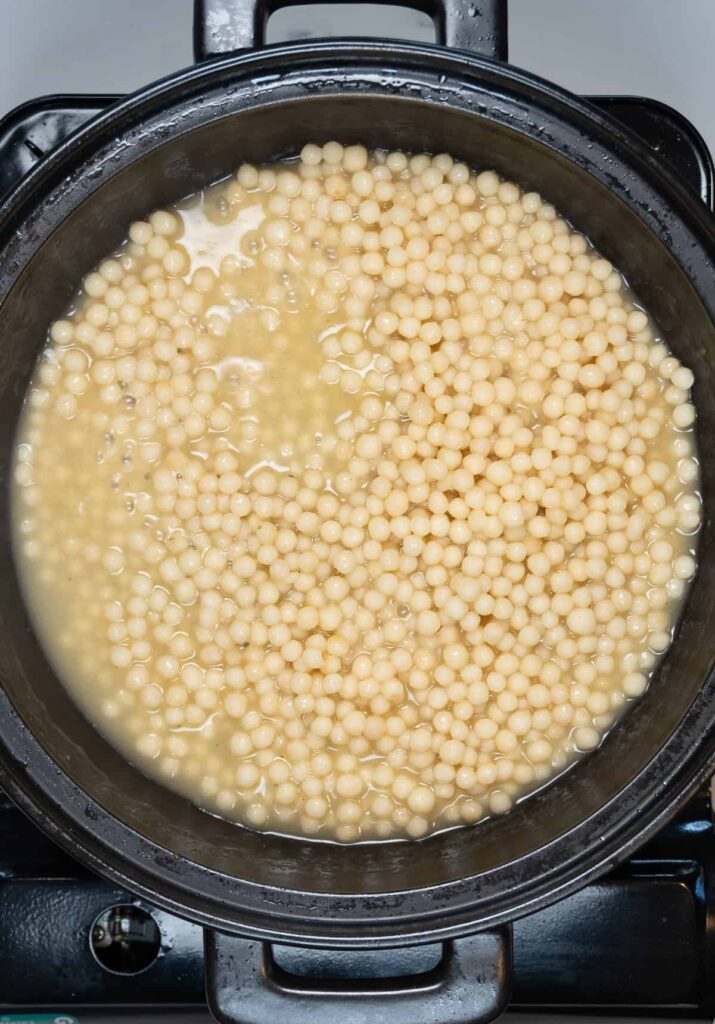 cooked pearl couscous in a black pan