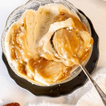 a glass bowl of caramel nice cream with a spoon in it
