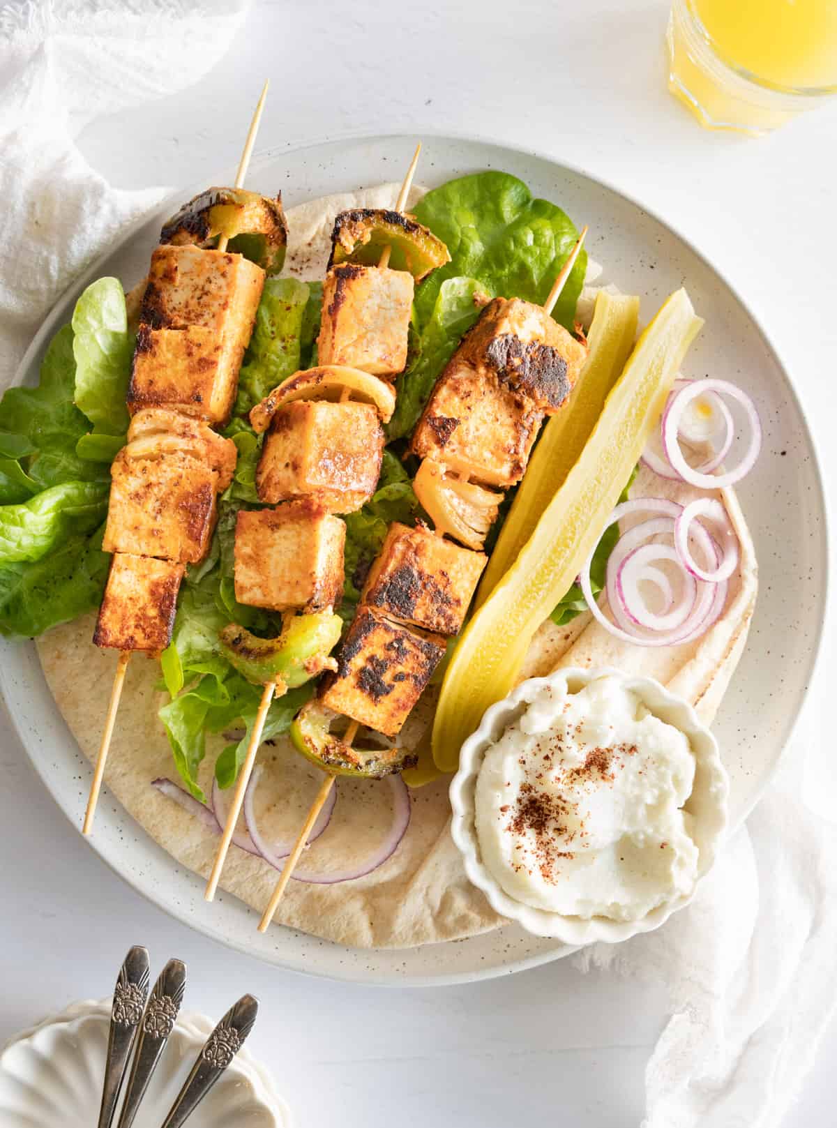 three tofy skewers on a bed of lettuce in a pita bread