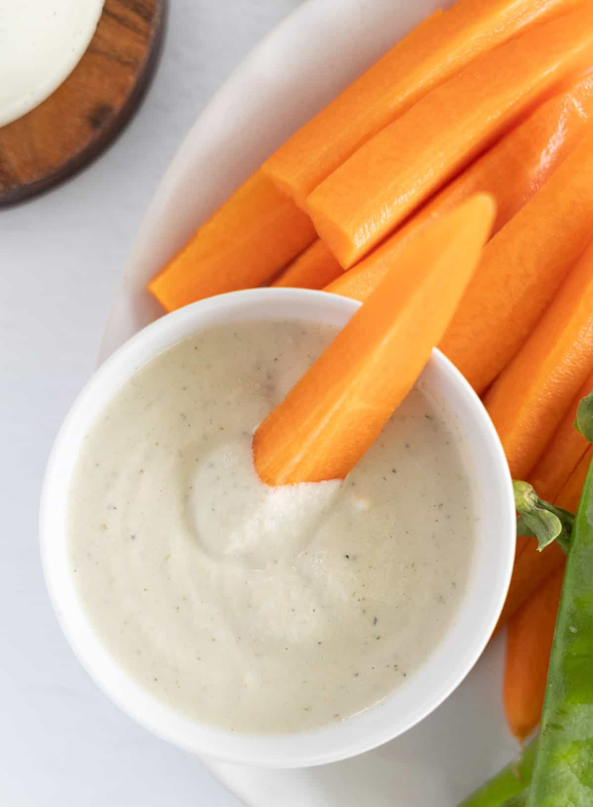 a carrot stick dipped in white sauce