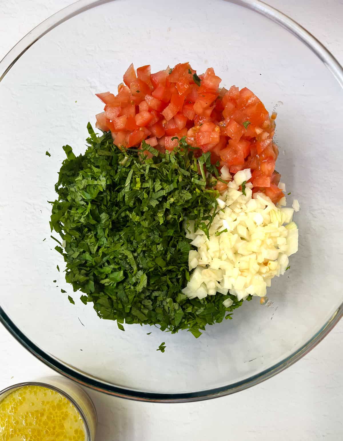 onion, tomato finely diced and finely sliced mint and parsley in a glass bowl