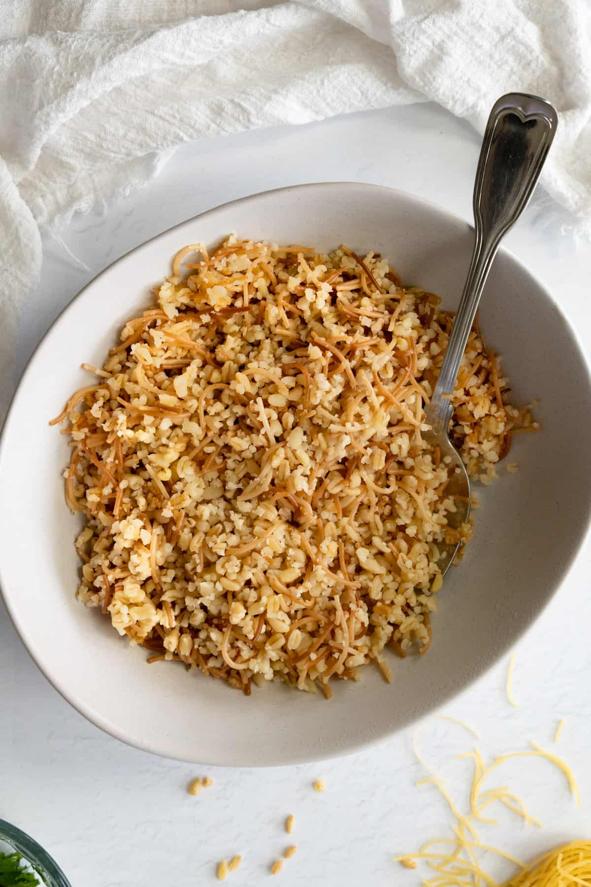 a white bowl filled with cooked bulgur with vermicelli