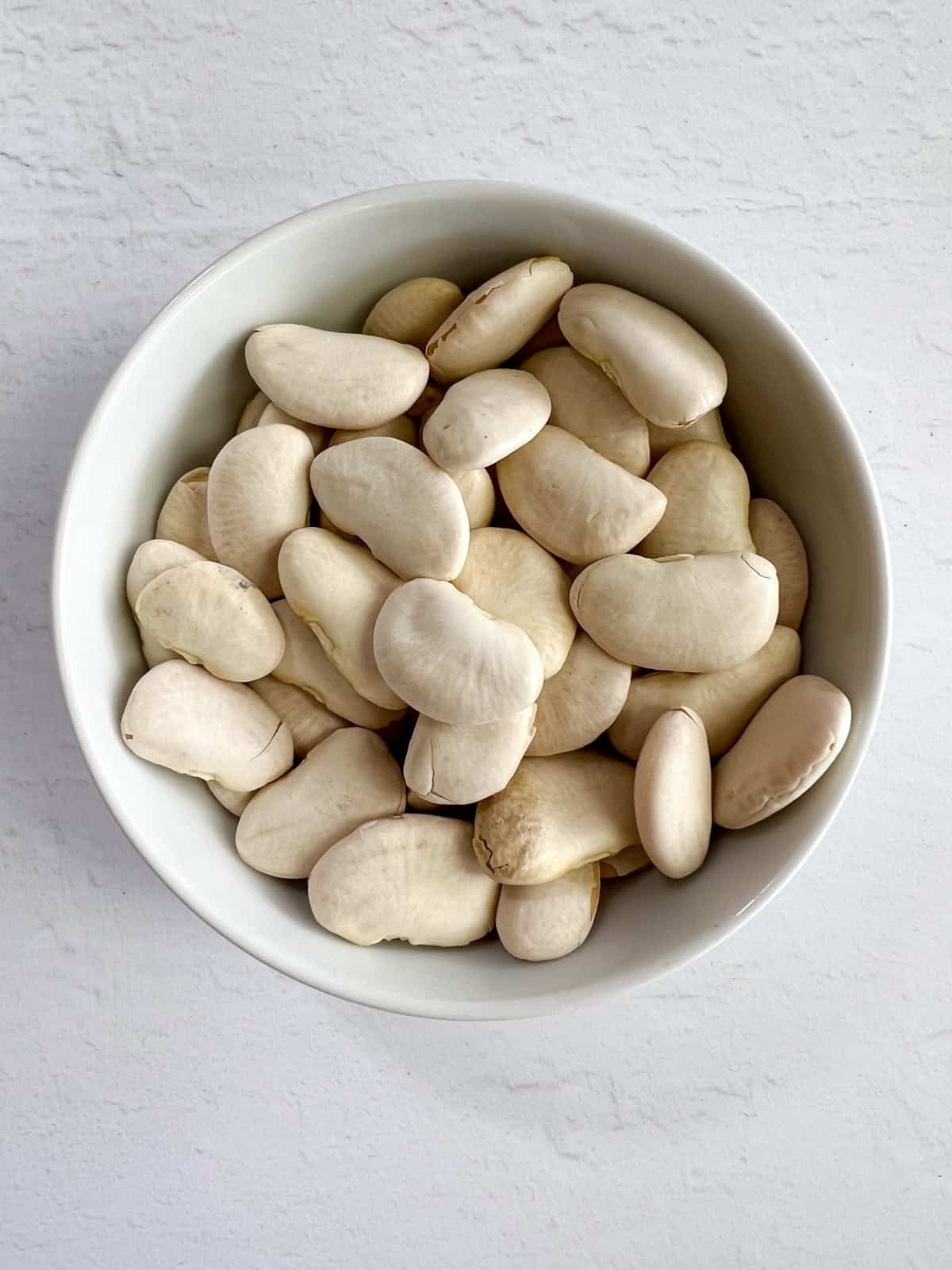 dry lima beans in a white bowl