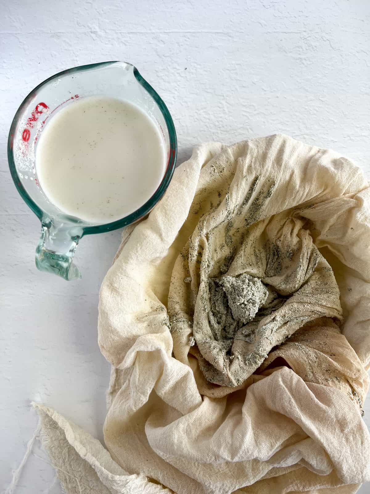a cloth with grey pulp and a jug with milk