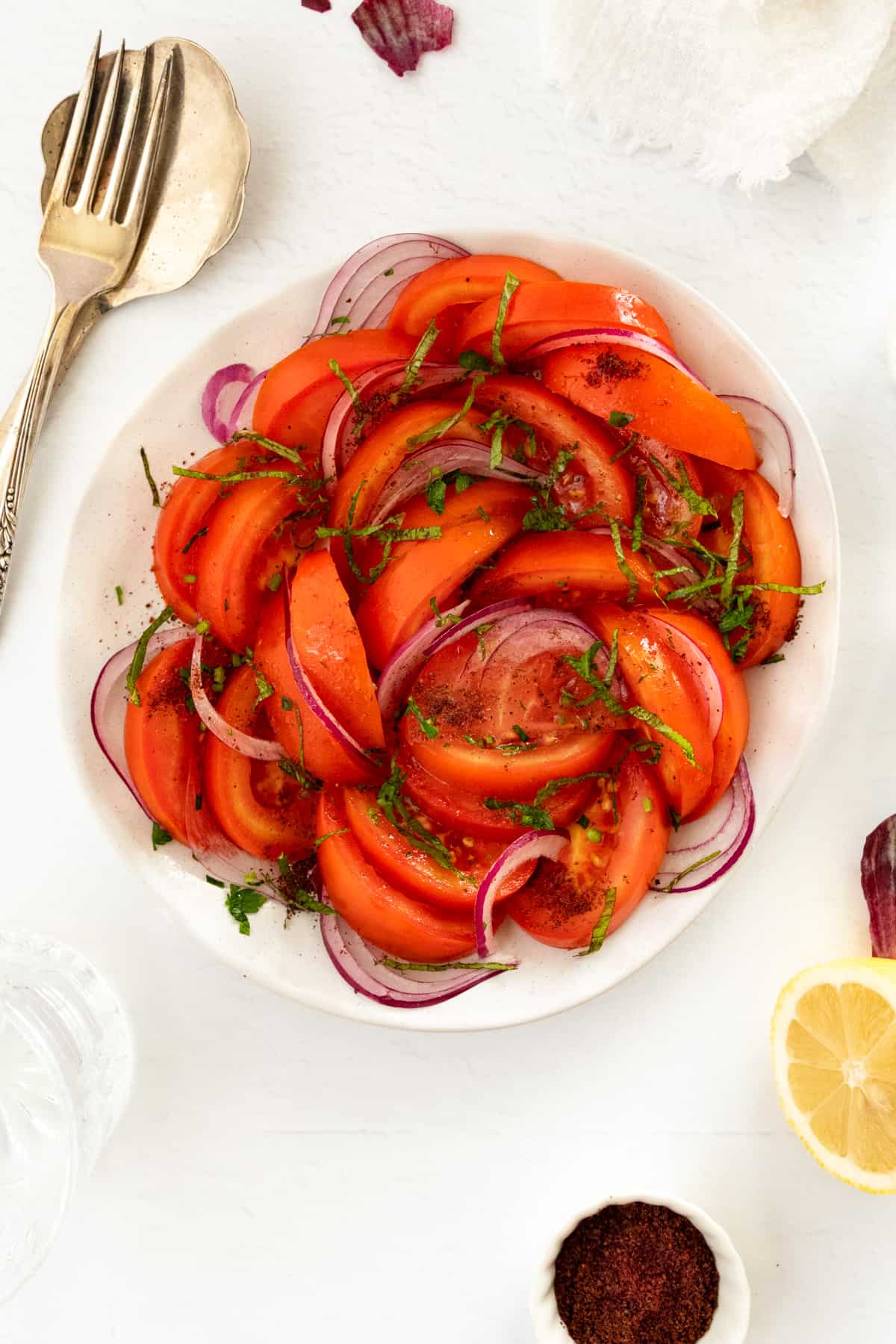 salad serving-ware next to a plate of tomato salad