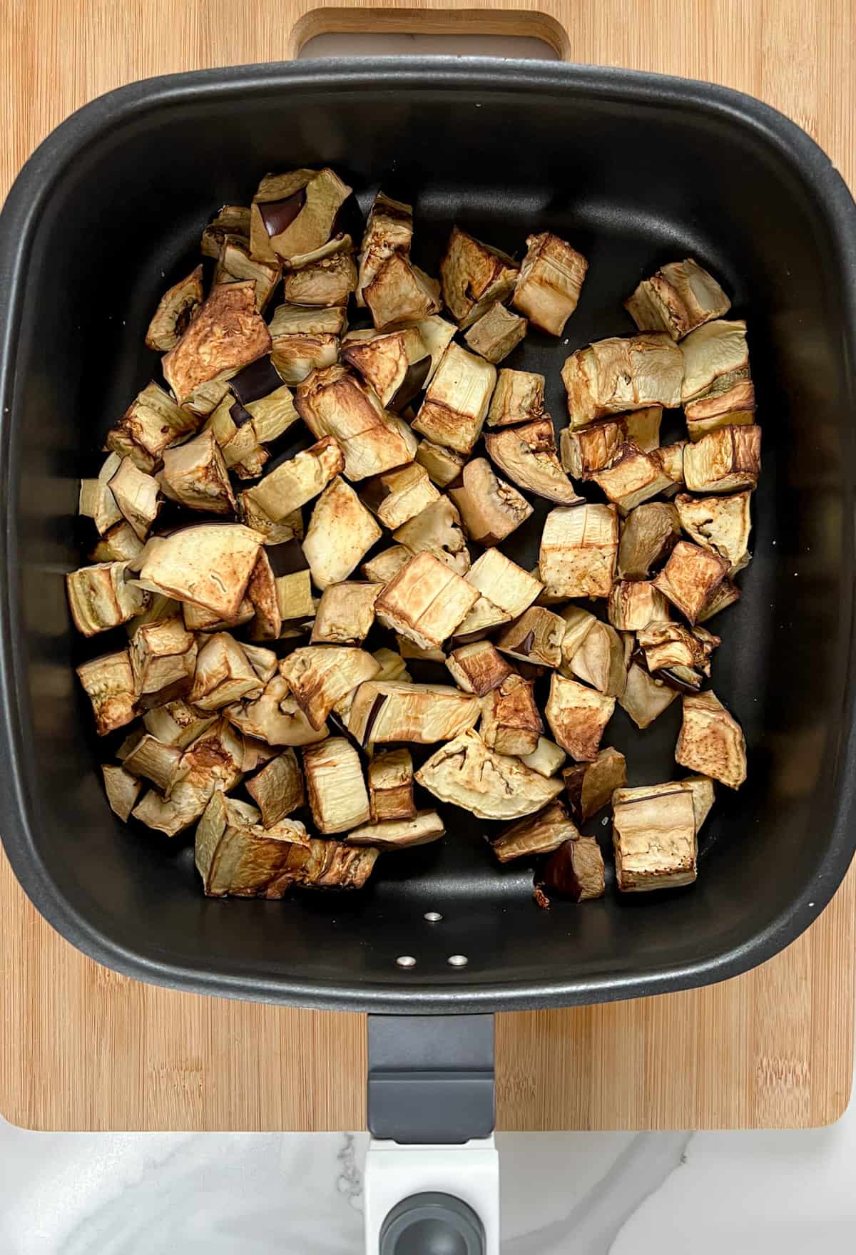 golden fried eggplant chunks in an air fryer pan