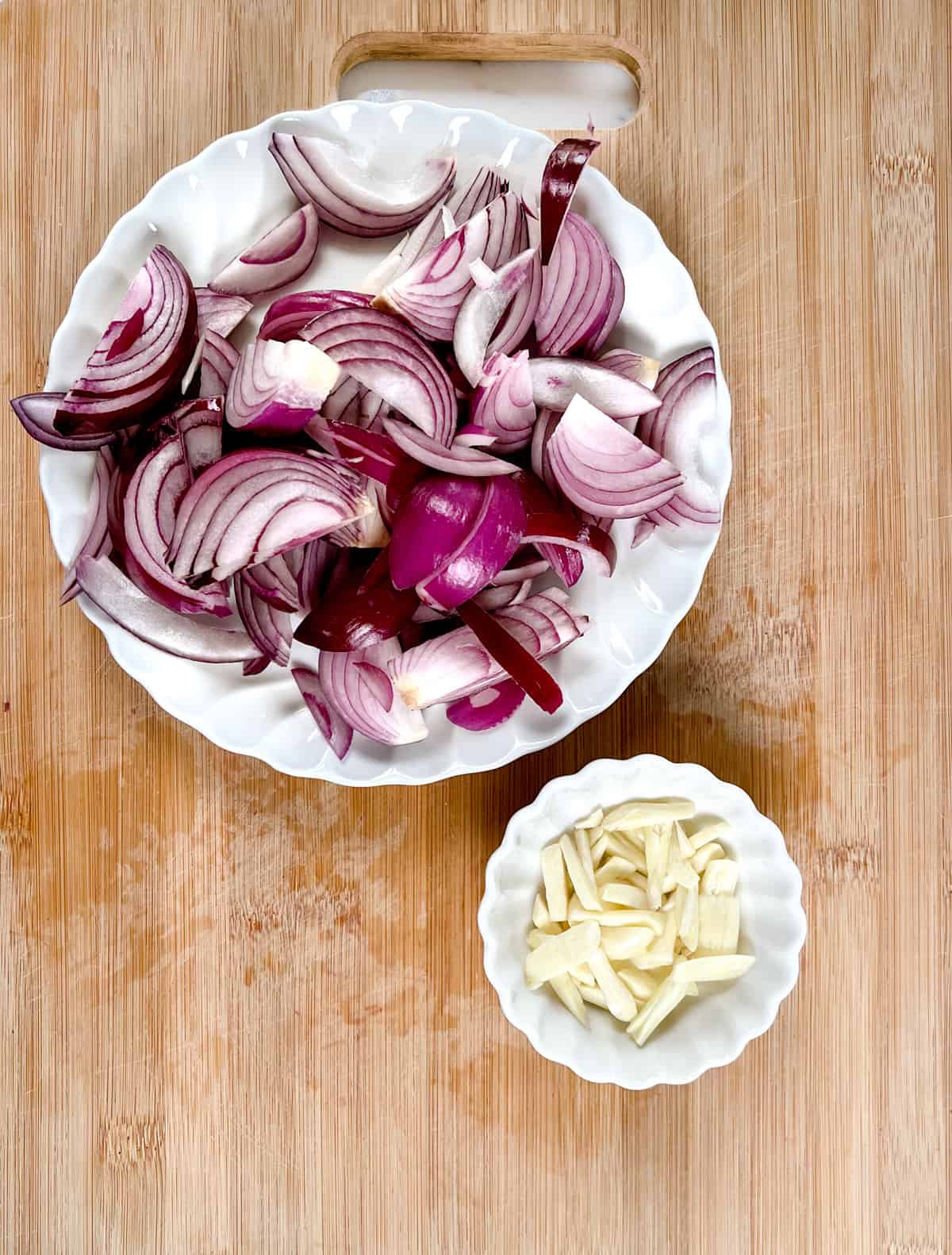 sliced red onion and garlic in white plates