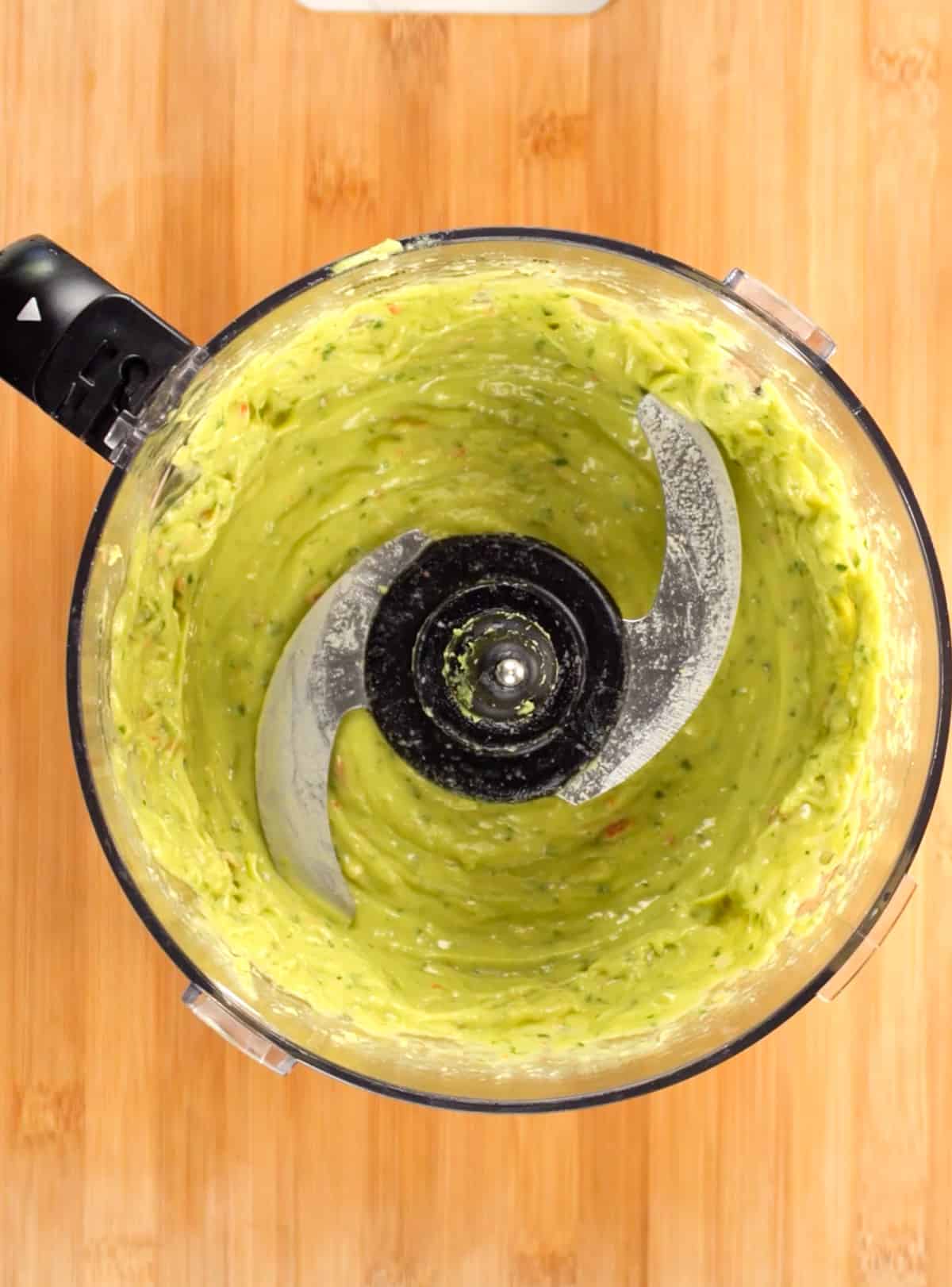 blended green dressing in a food processor bowl
