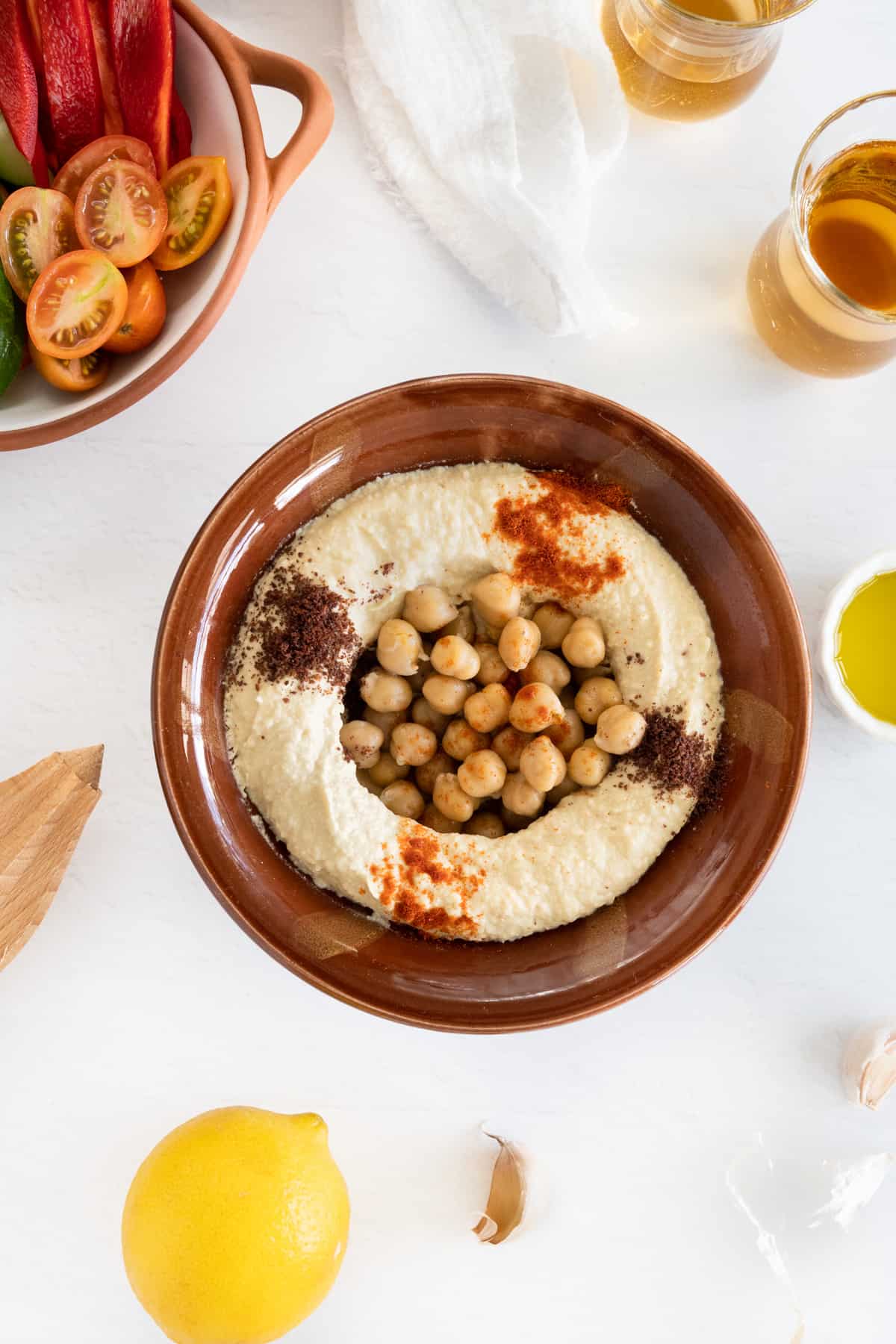 a brown ceramic bowl filled with creamed chickpeas and garnished with red spices