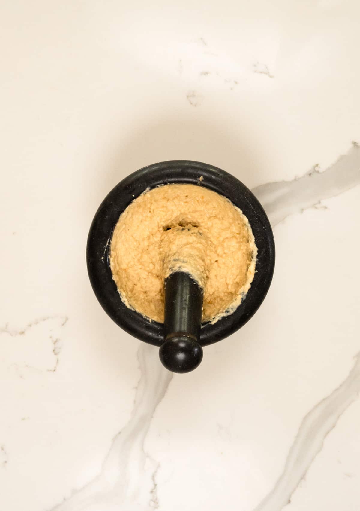 a pestle and mortar with crushed chickpea dip