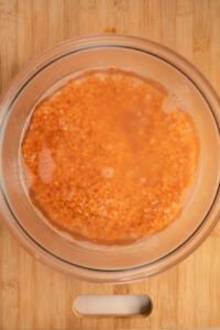 red lentils soaking in water in a glass bowl