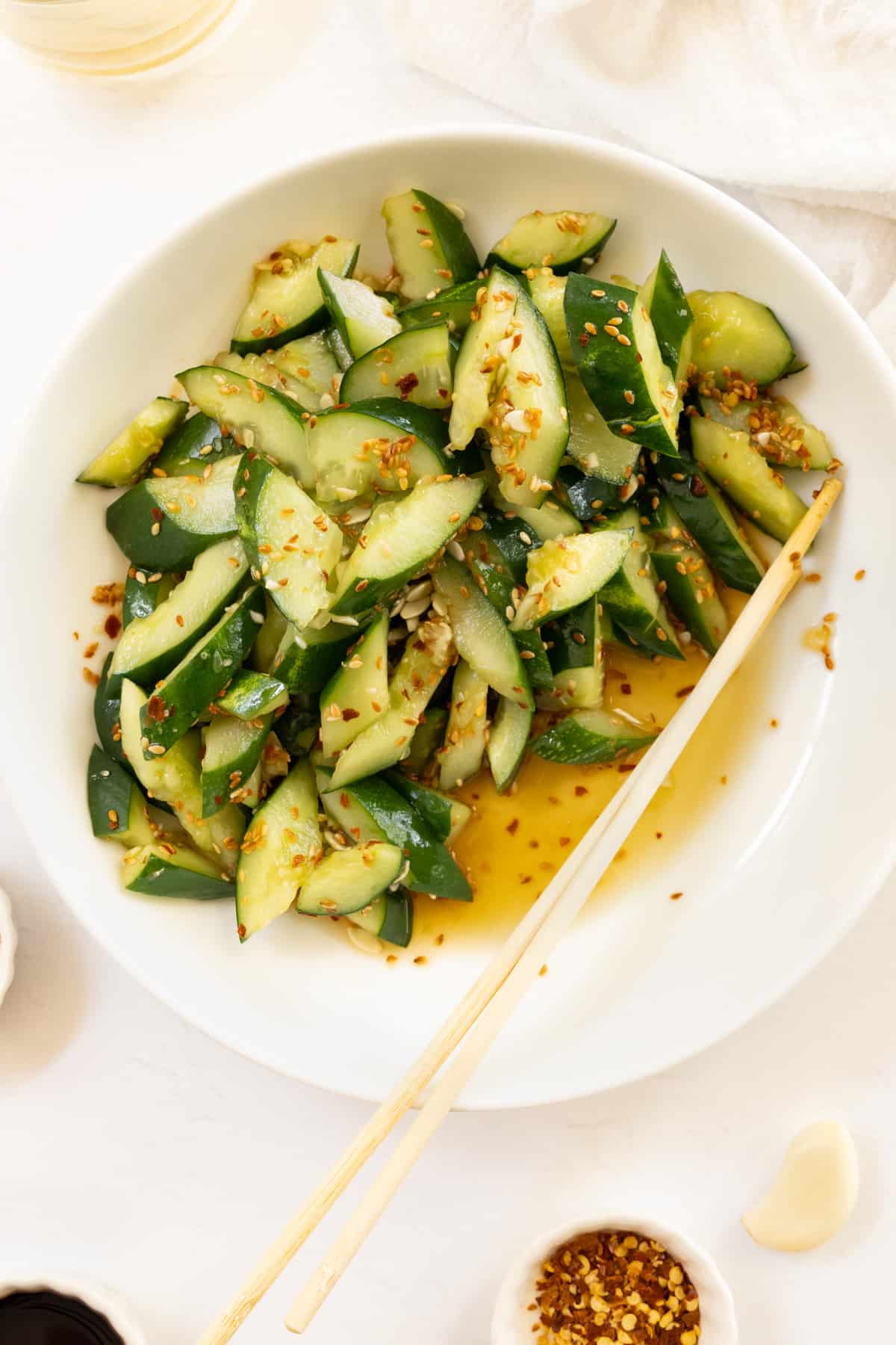 cucumber pieces in a brownish dressing in a white bowl