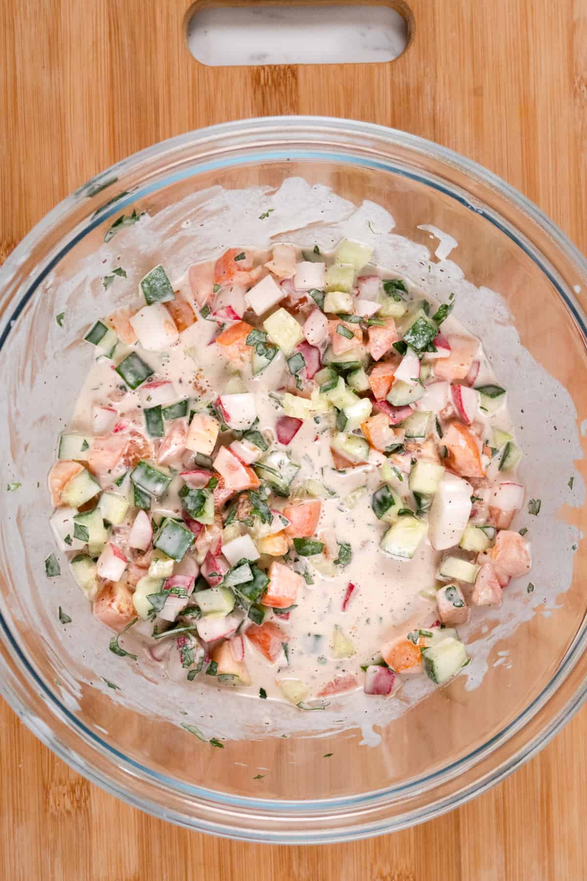 a salad mixed with white sauce