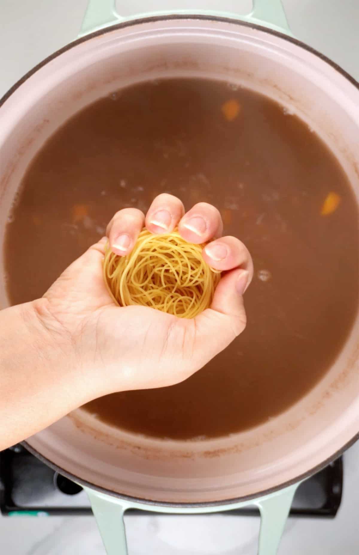 crushing vermicelli noodle into soup