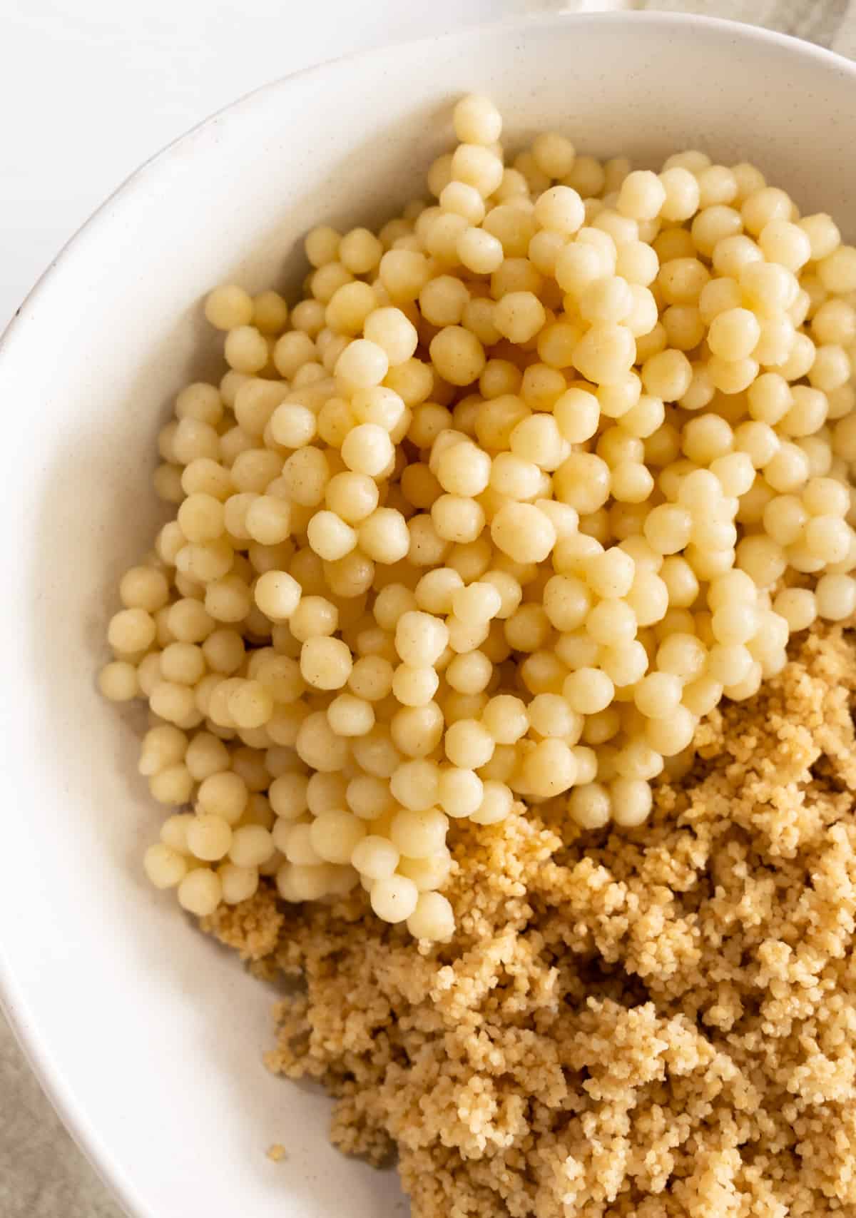 cooked plain pearl couscous in a white bowl