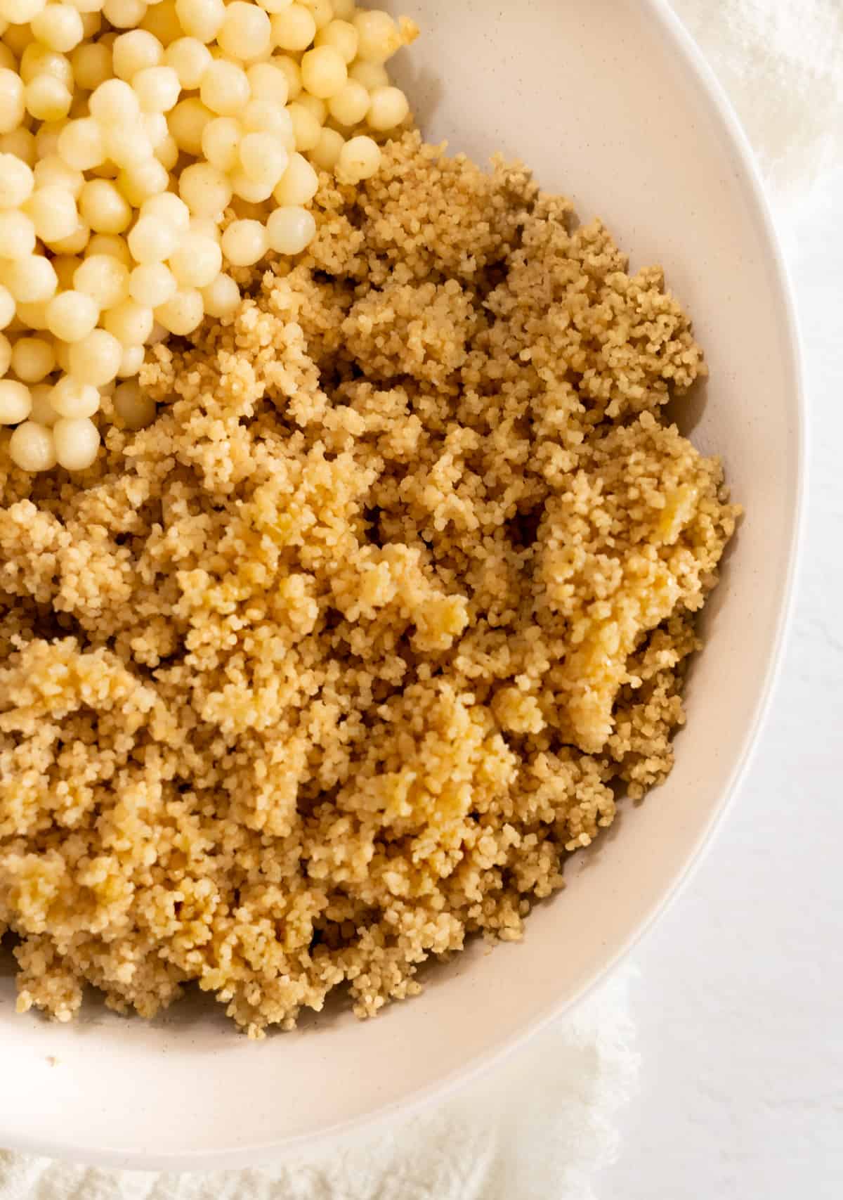 cooked plain small couscous in a white bowl