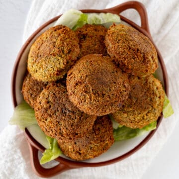 a brown bowl with golden round falafel