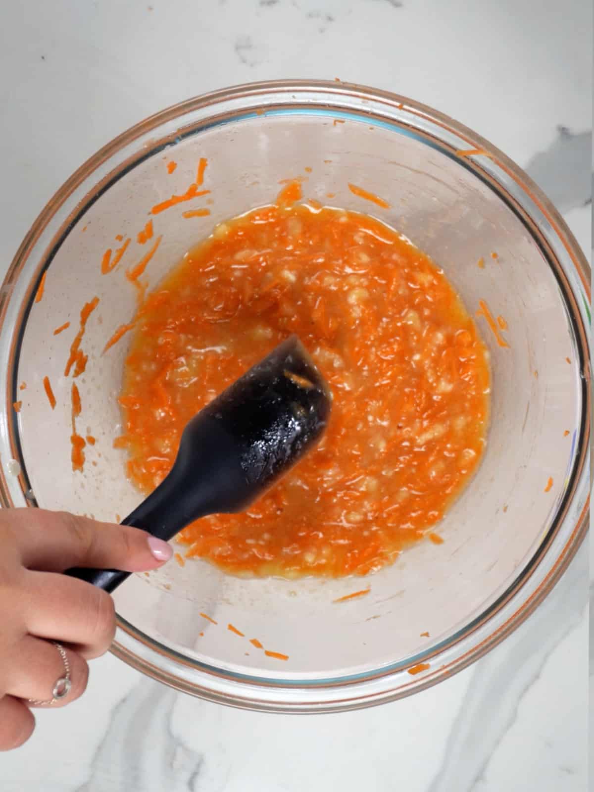 shredded carrots in a wet  ingredients in a glass bowl