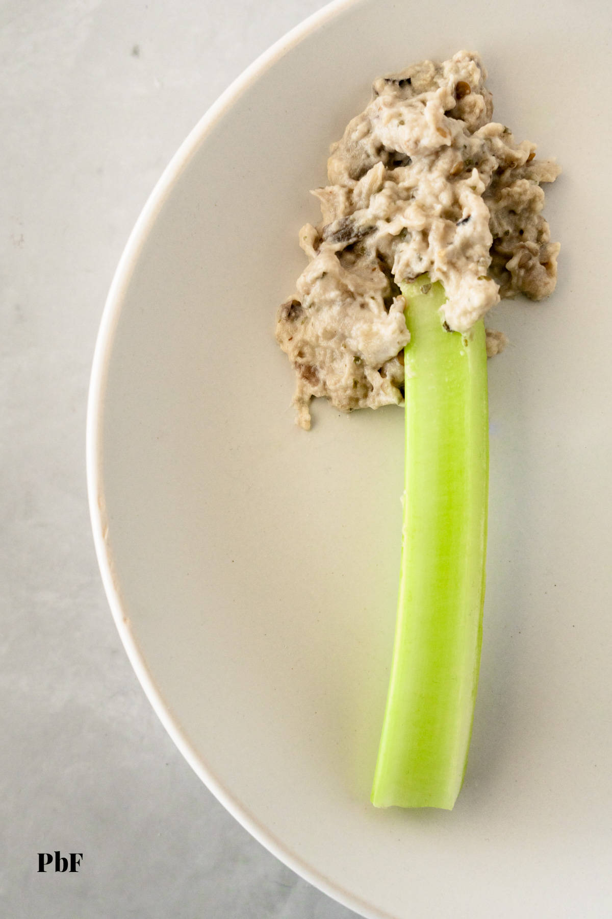 a celery stick with baba ganoush on it