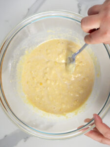 whisking the corn pancakes batter in a bowl