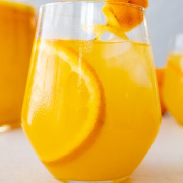 a cup of orangeade with a slice of orange