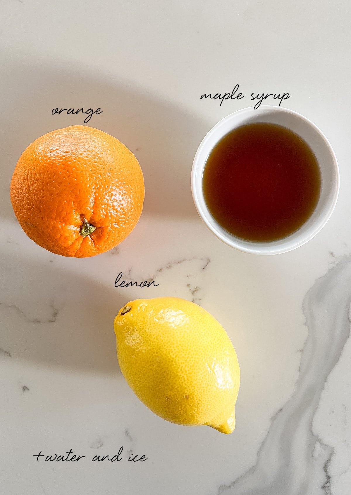 an orange, lemon and maple syrup in a bowl