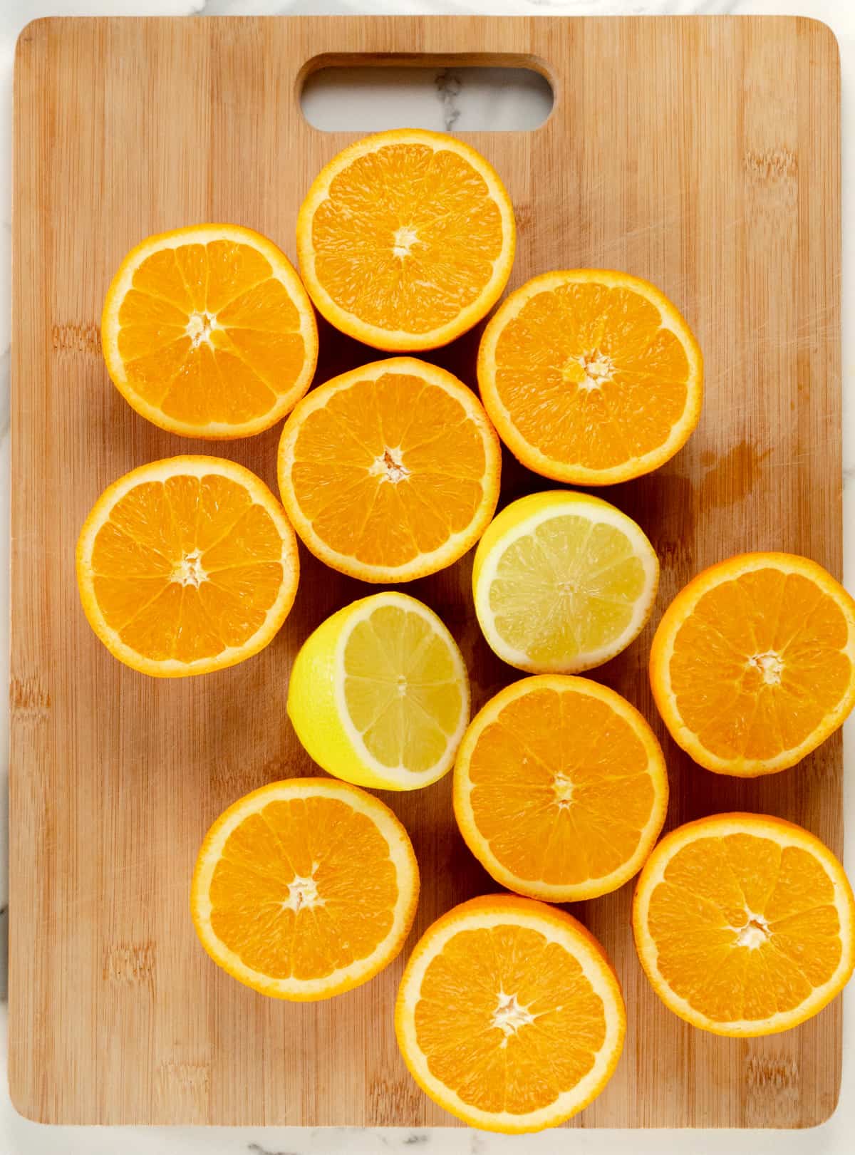 oranges and lemons laid out on a wood chopping board