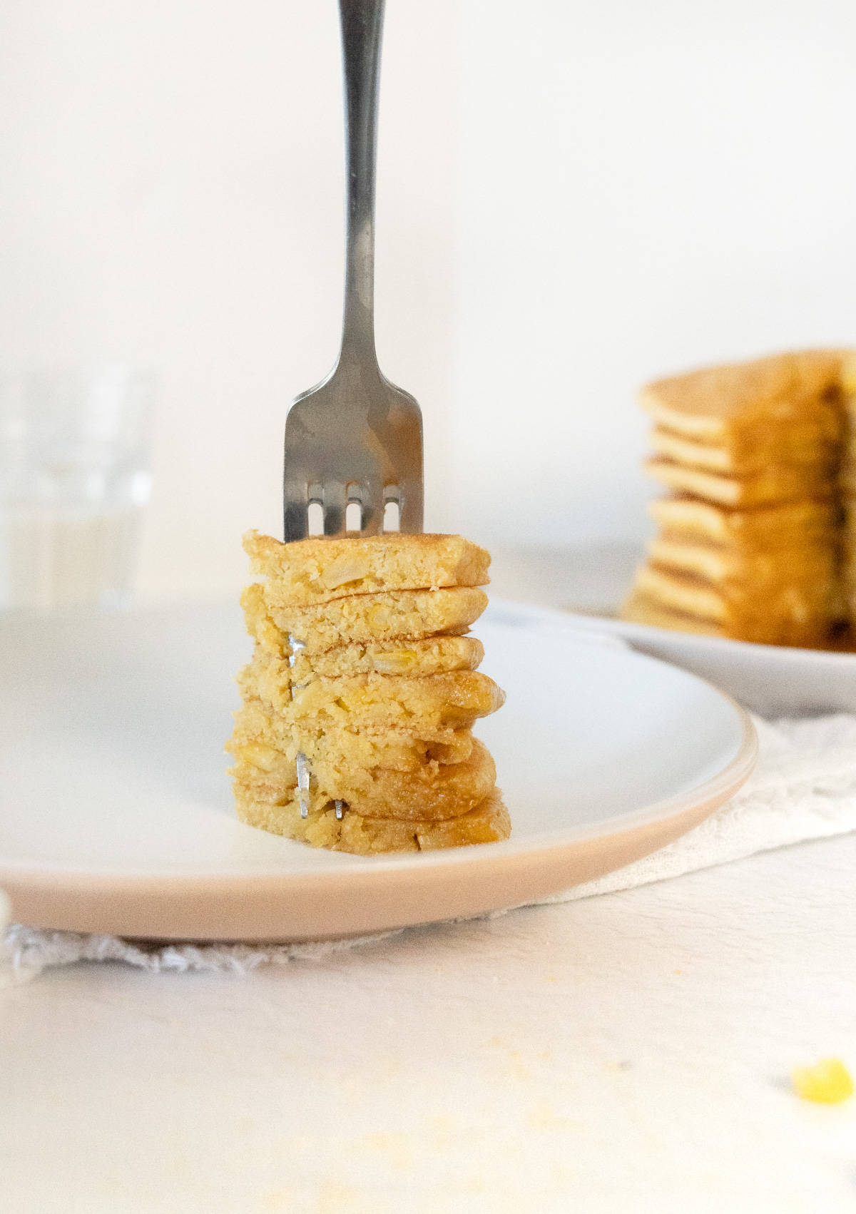 a fork with a mouthful of sliced corn pancakes