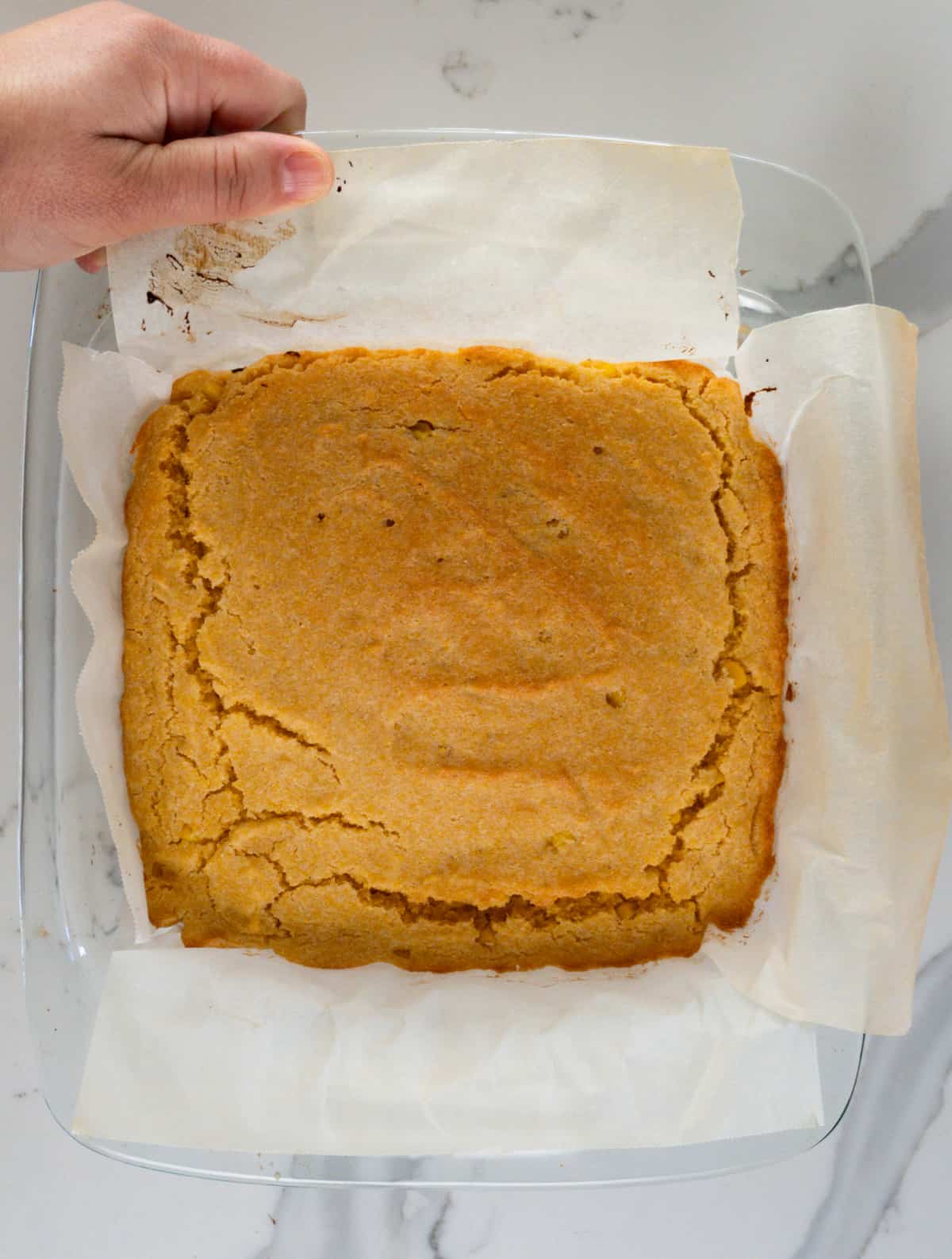 a square slab of vegan gluten free cornbread on parchment paper