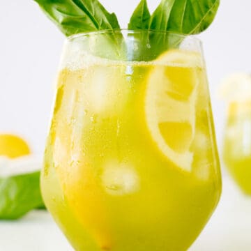 a cup of basil lemonade garnished with fresh basil leaves