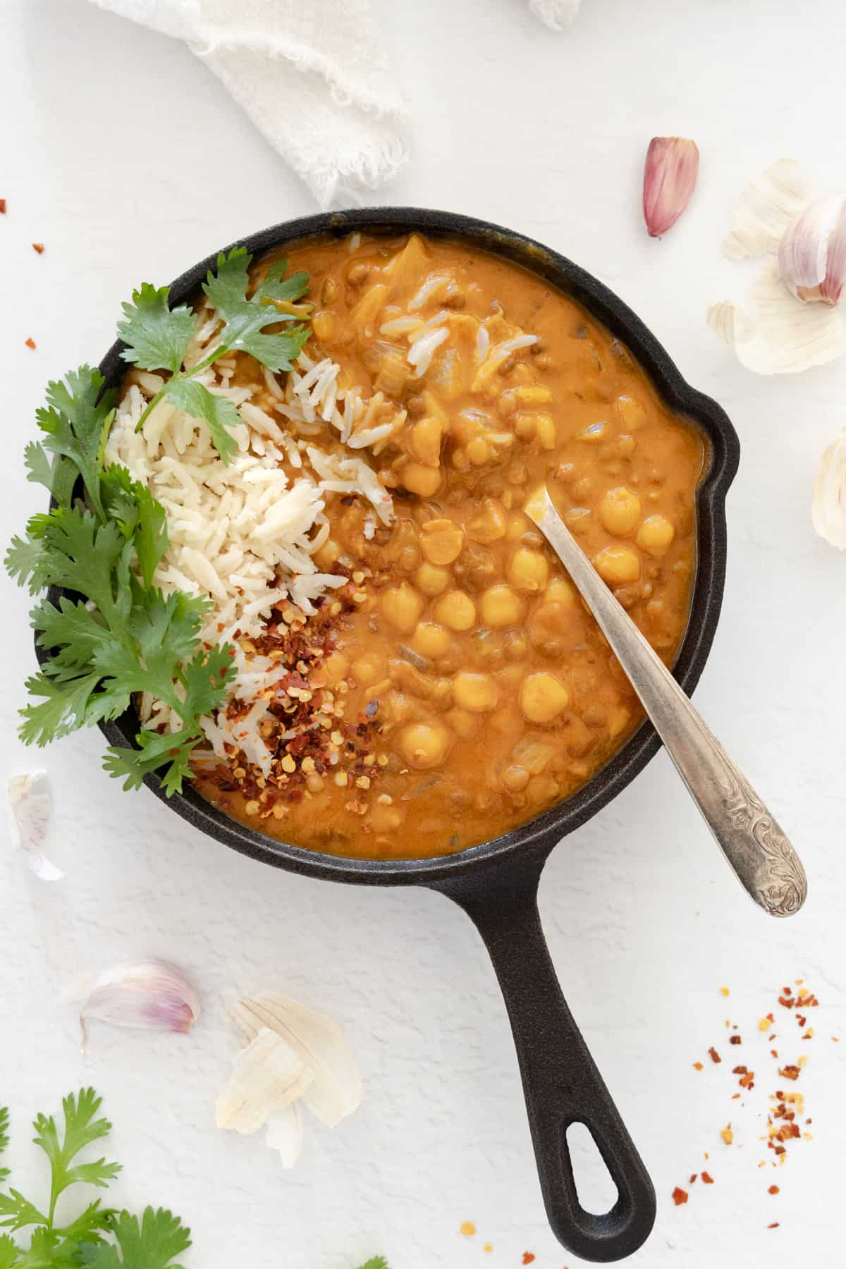 a cast iron pan with creamy chickpea and lentil curry and a side of rice