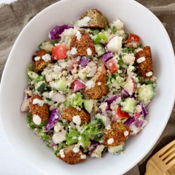 a white bowl with falafel salad in it