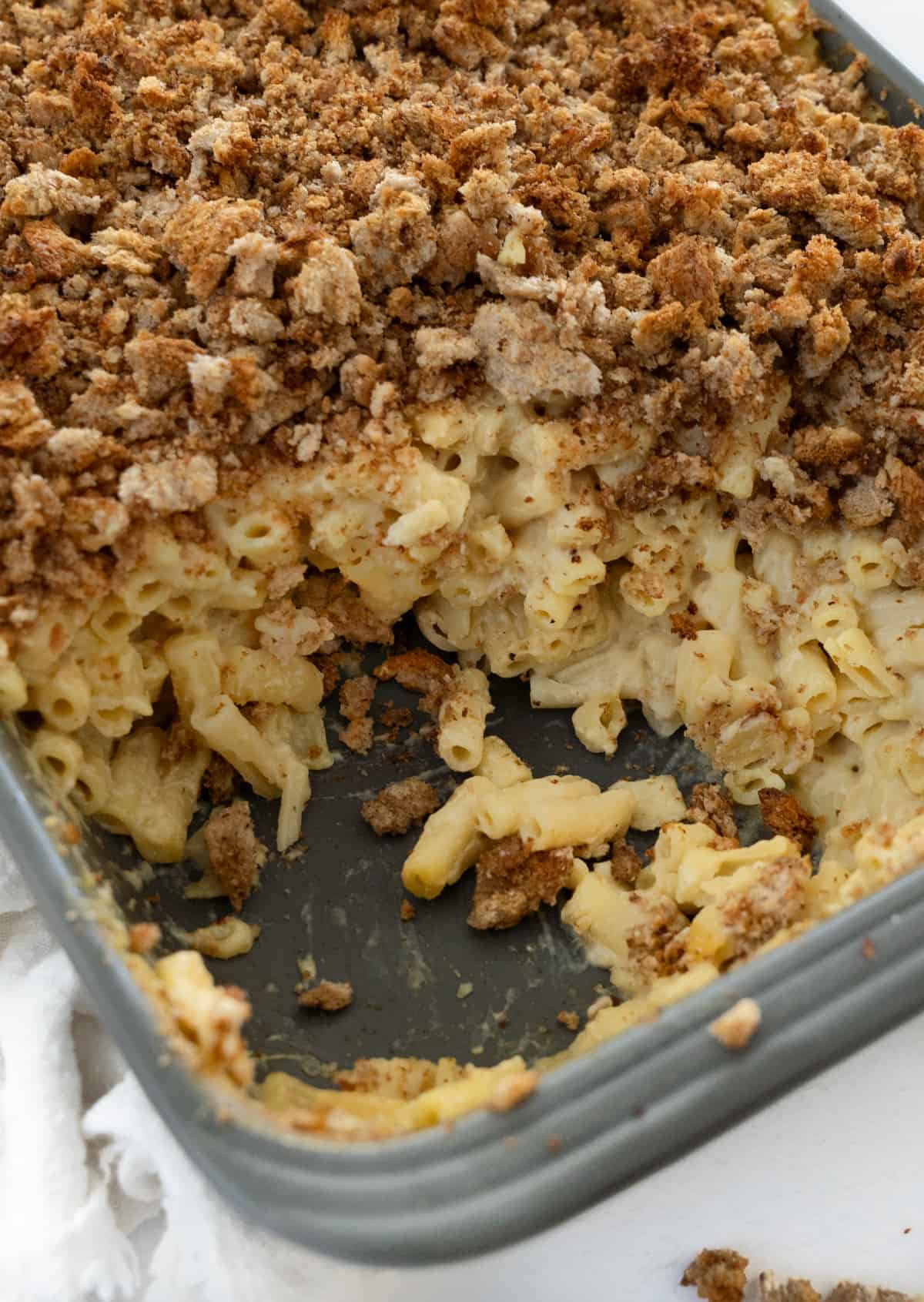 baked vegan mac and cheese in a baking dish with some of it taken out