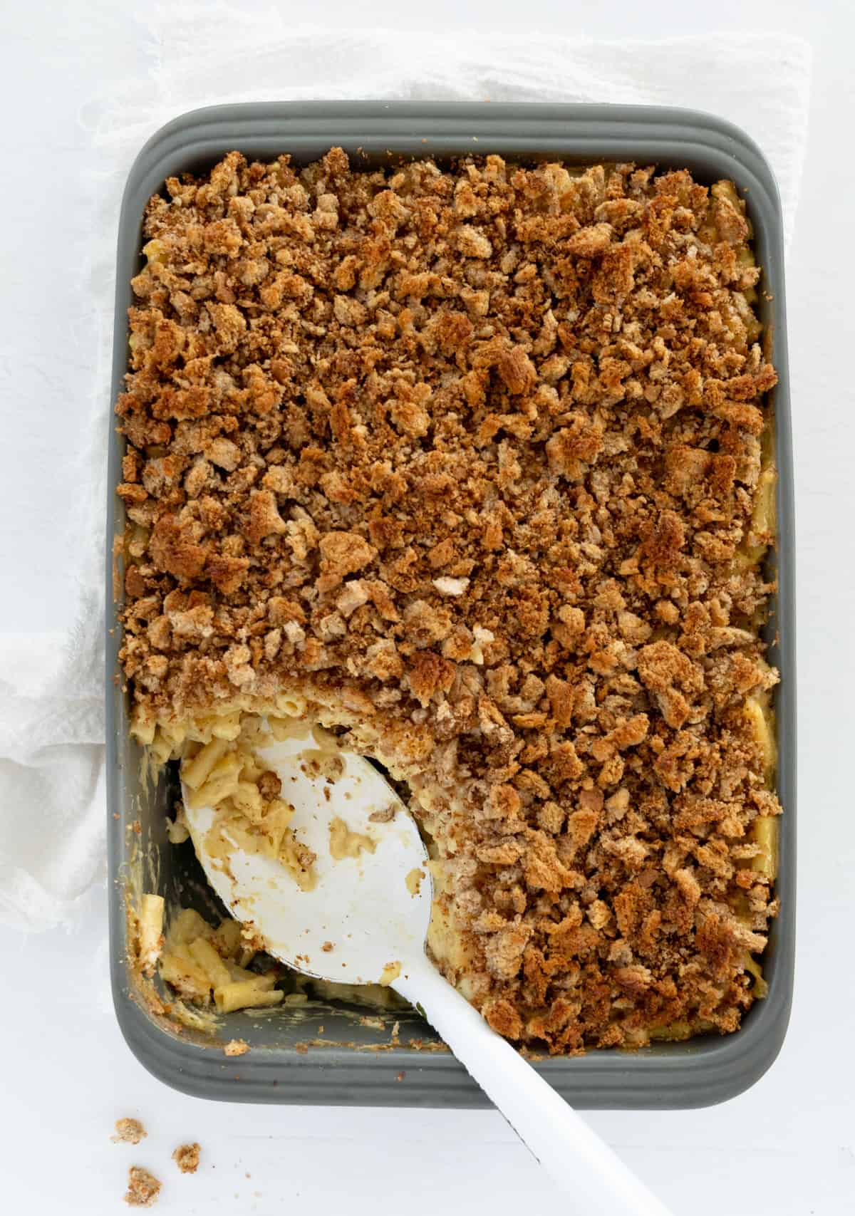 a casserole dish filled with vegan baked mac and cheese topped with bread crumbs