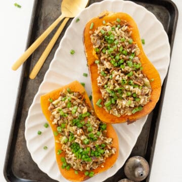two vegan stuffed butternut squash filled with lentils and rice