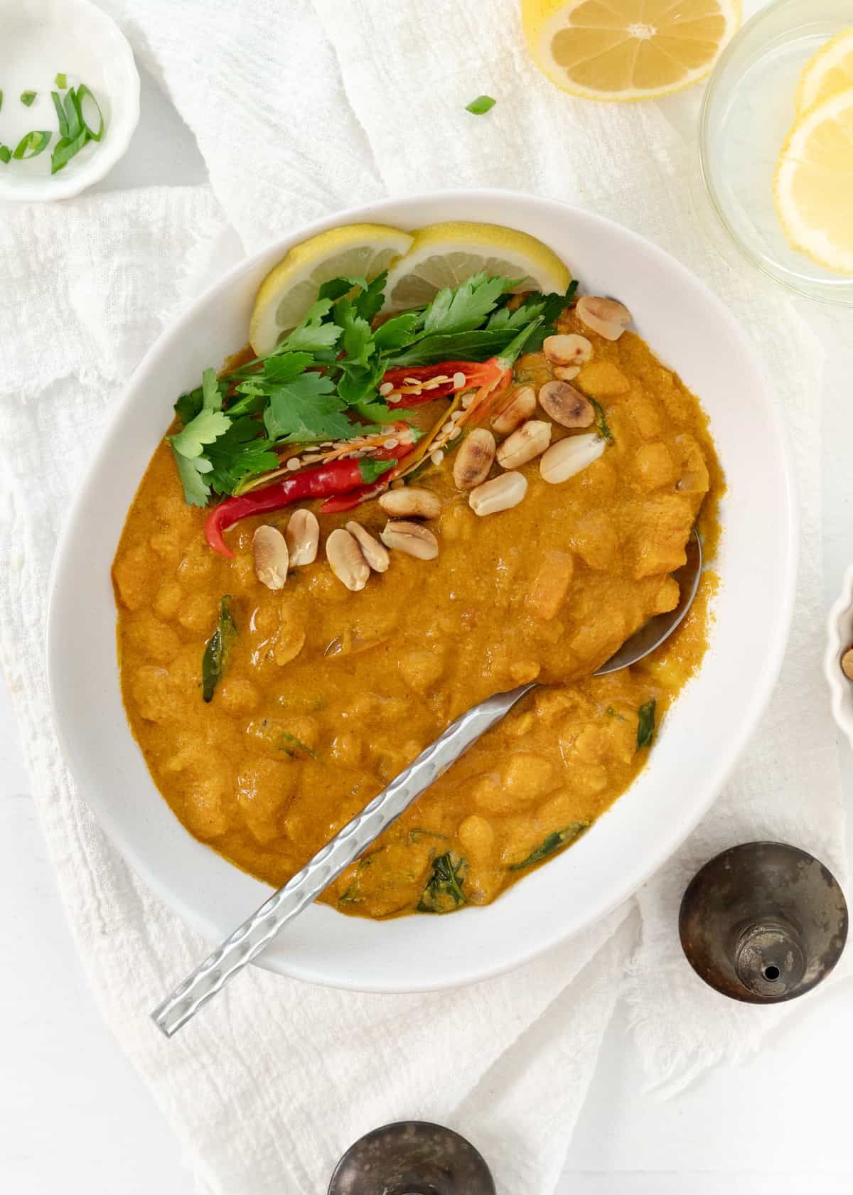 a bowlf of peanut butter curry with a spoon in it