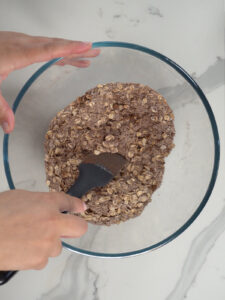 hand mixing dry cocoa powder and oat flour together